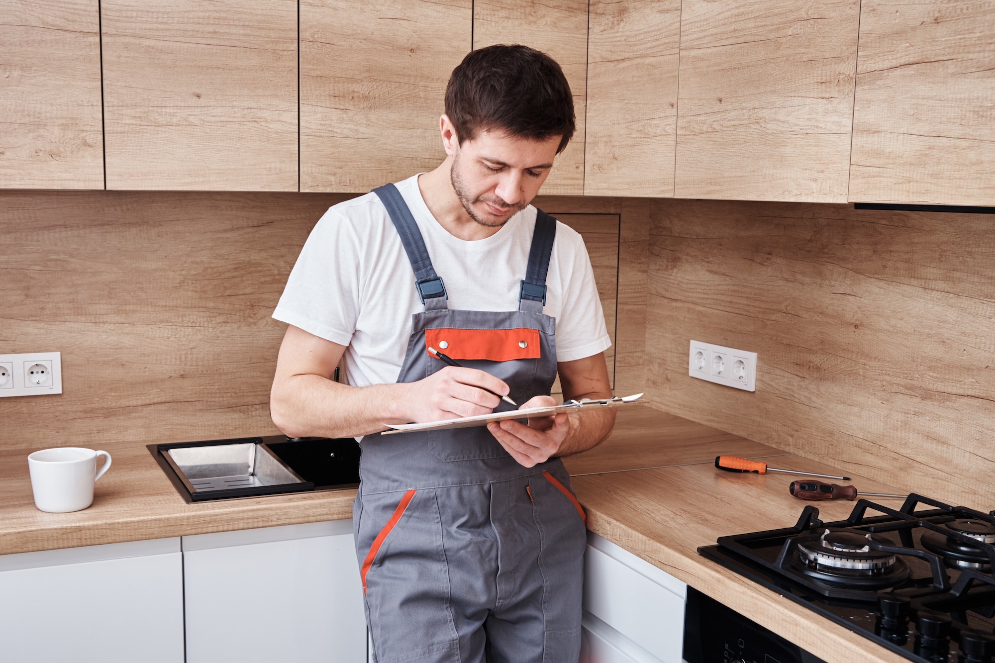 Plumber signs a contract for the services in the kitchen