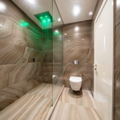 Shower and toilet in contemporary bathroom designed in minimal style in apartment.